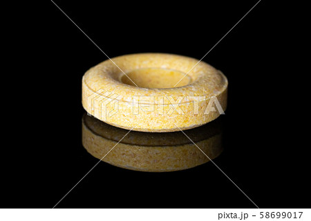 Pale round candy isolated on black glass 58699017