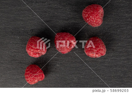 Fresh red raspberry on grey stone Fresh red raspberry on grey stone 58699203