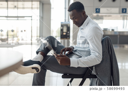 Black businessman using laptop in car showroom Black businessman using laptop in car showroom 58699493