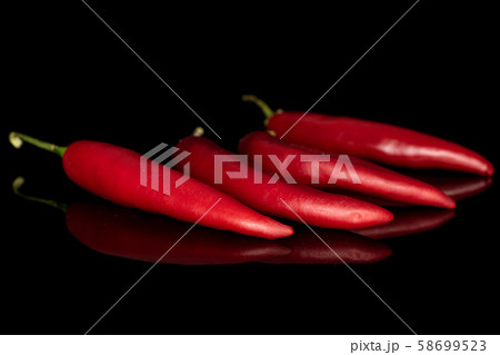 Red hot cayenne chili isolated on black glass Red hot cayenne chili isolated on black glass 58699523