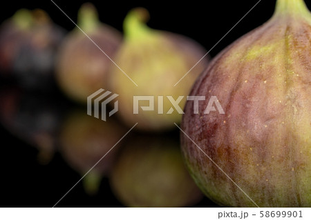 Sweet purple fig isolated on black glass 58699901