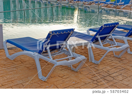 Beach chairs near swimming pool Beach chairs near swimming pool 58703402
