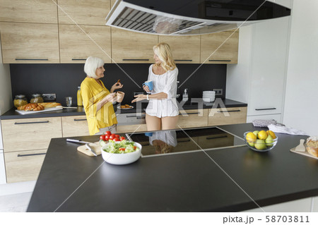 Two adult women talking with coffee at home 58703811