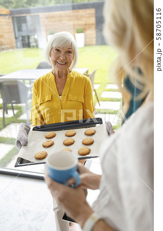 Smiling mature lady doing baking in the kitchen Smiling mature lady doing baking in the kitchen 58705116