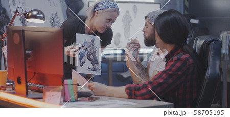 Developers discussing video game artwork Developers discussing video game artwork 58705195