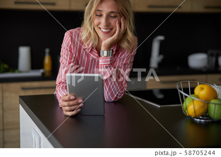 Happy young lady is using tablet at home Happy young lady is using tablet at home 58705244