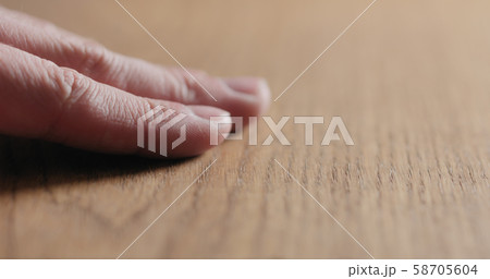 man hand touch oil finished oak wood surface 58705604