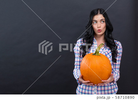 Young woman holding a pumpkin 58710890
