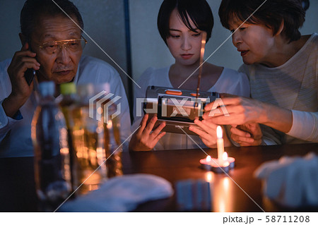 停電した部屋で台風がすぎるのを待つ家族 58711208