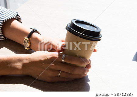 コーヒーカップを持つ手の写真素材