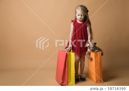 A young girl in a red dress and with shopping bags, happy shopping 58716390