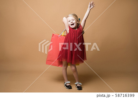 A young girl in a red dress and with shopping bags, happy shopping 58716399