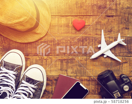 flat lay of passport ,mobile, plane model , sneakers , phone , camera and traveler's accessories items on wooden background with copy space. travel and vacation concept 58718256