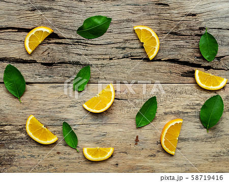 composition of slices, whole of orange fruits with green leaves on wooden background. top view composition of slices, whole of orange fruits with green leaves on wooden background. top view 58719416