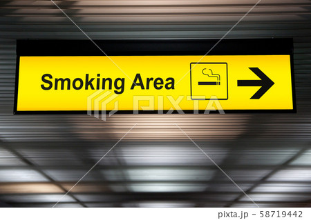 smoking area sign with icon and arrow pointing to smoking area zone hanging from airport ceiling at international terminal. designated smoking areas for separate the smokers from the non-smoking zone smoking area sign with icon and arrow pointing to smoking area zone hanging from airport ceiling at international terminal. designated smoking areas for separate the smokers from the non-smoking zone 58719442