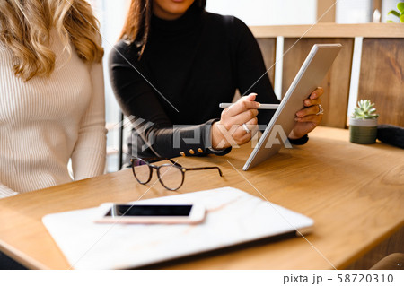 Close-up of Professional Team Discussing Over Digital Tablet At Cafe Close-up of Professional Team Discussing Over Digital Tablet At Cafe 58720310
