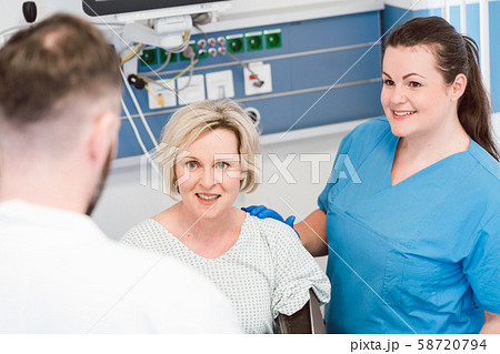 Patient in recovery room of hospital talking to doctor 58720794
