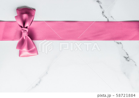 Pink silk ribbon and bow on marble background, 58721884