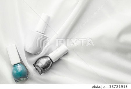 Nail polish bottles on silk background, french 58721913