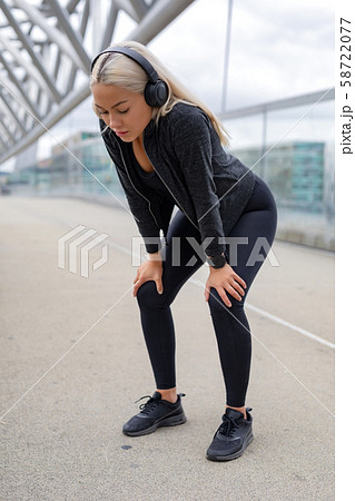 Tired Woman Resting With Hands On Knees After Running Workout 58722077