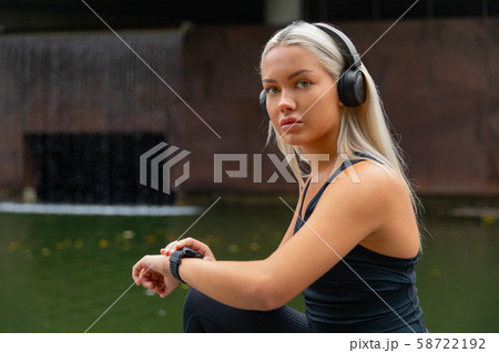 Woman setting up fitness smart watch device for running 58722192