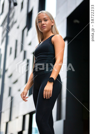 Beautiful Fitness Woman Standing Against Futuristic Modern Building In City 58722233