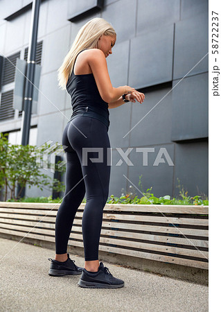 Urban woman using fitness smart watch device before running 58722237