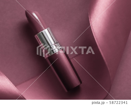 Luxury lipstick and silk ribbon on purple holiday Luxury lipstick and silk ribbon on purple holiday 58722341