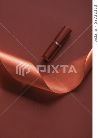 Luxury lipstick and silk ribbon on bronze holiday Luxury lipstick and silk ribbon on bronze holiday 58722353