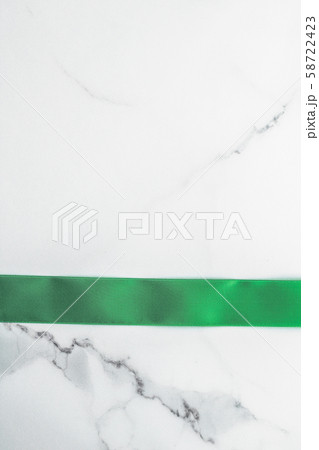 Green silk ribbon and bow on marble background, St 58722423