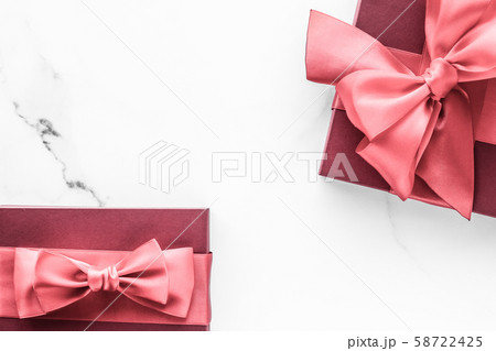 Coral gift box with silk bow on marble background, 58722425