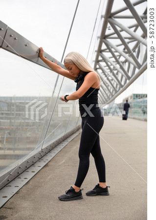 Woman Checking Heart Rate Using Smartwatch After Workout On Bridge 58723003