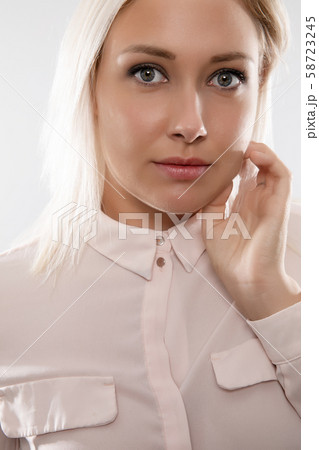 Beautiful female blonde model in shirt holding her hair Beautiful female blonde model in shirt holding her hair 58723245
