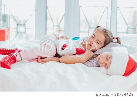 Two exhausted kids are sleeping, cuddling sweetly after new year party. Two exhausted kids are sleeping, cuddling sweetly after new year party. 58724428