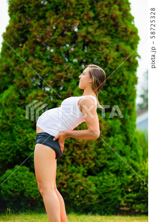 Pregnant Woman Practicing Half Wheel Pose In Park 58725328