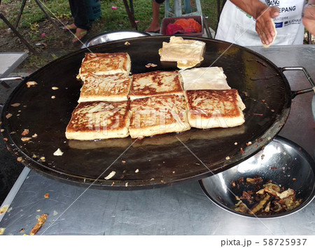 Malaysian street food called Murtabak. In it there is a mixture of meat, eggs and onions. Eaten with a special gravy. Malaysian street food called Murtabak. In it there is a mixture of meat, eggs and onions. Eaten with a special gravy. 58725937