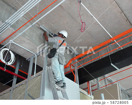 Drywall installation work in progress by construction workers at the construction site. It is the easiest and cheapest way to do partition for interior wall.  58728005