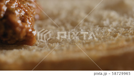 Extreme closeup spread red pesto on ciabatta slice 58729965