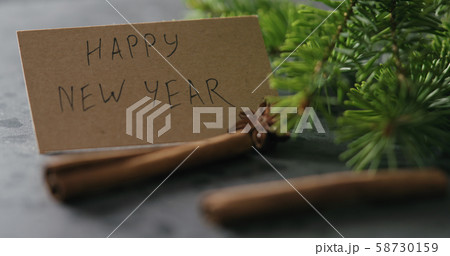 spruce twig with happy new year card on terrazzo countertop with natural decorations 58730159