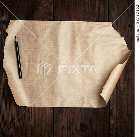torn empty sheet of brown paper and a black pencil torn empty sheet of brown paper and a black pencil 58732162