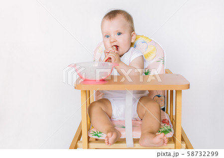 Baby girl with spoon on white background 58732299