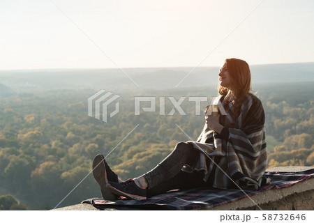 Young pregnant woman with sits on a hill and looks 58732646