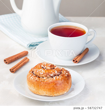 One cinnamon bun on  white plate 58732747