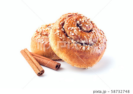 Two cinnamon buns and cinnamon sticks isolated 58732748