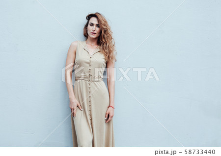 Portrait of a beautiful fashionable woman in a beige dress on a walk Portrait of a beautiful fashionable woman in a beige dress on a walk 58733440