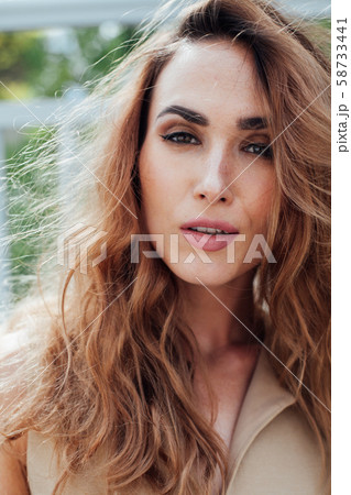Portrait of a beautiful fashionable woman in a beige dress on a walk Portrait of a beautiful fashionable woman in a beige dress on a walk 58733441