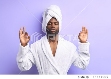 Peaceful african man doing yoga and meditate iolated over purple hite background Peaceful african man doing yoga and meditate iolated over purple hite background 58734005