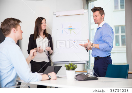 Male Professional Explaining Chart To Coworkers In Office 58734033