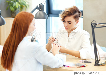Nail Care And Manicure. Redhead woman came to manicure salon Nail Care And Manicure. Redhead woman came to manicure salon 58734100