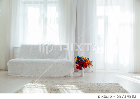 sofa with flowers in the interior of the white room of the house sofa with flowers in the interior of the white room of the house 58734882